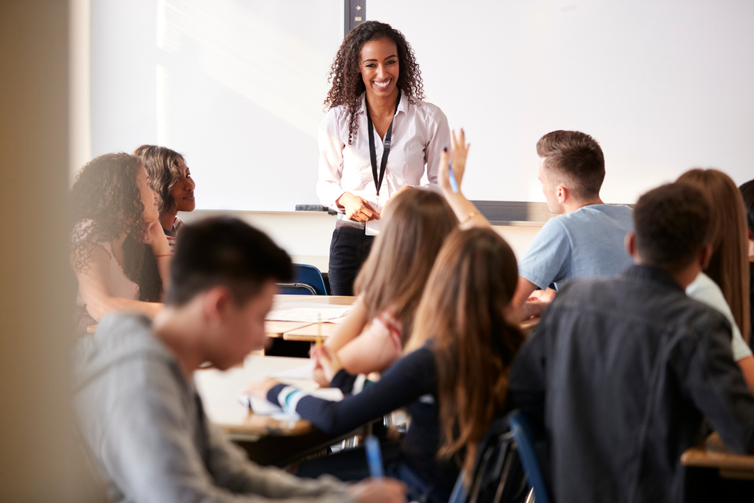 Female High School Teacher Standing in Front of Interactive Whit