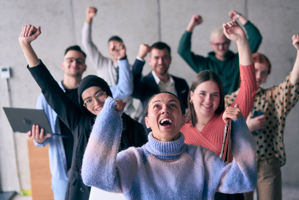 A diverse group of successful businessmen raises their hands in the air, symbolizing achievement, accomplishment, and the fulfillment of goals, exuding confidence, unity, and celebration of their collective success.